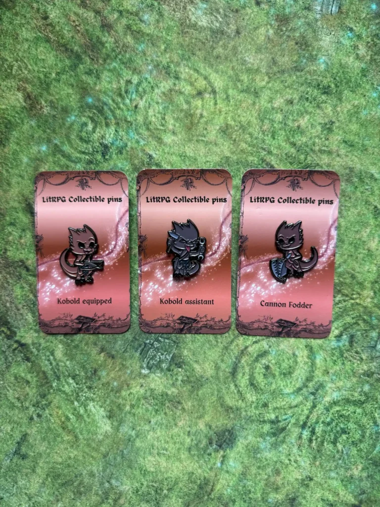 Kobold equipped, Kobold assistant and Cannon Fodder collectible pins on a green mat