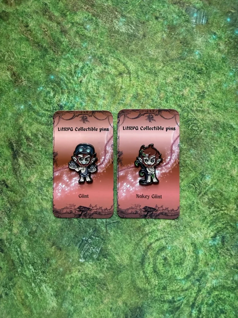Glint and Nakey Glint collectible pins on a green mat